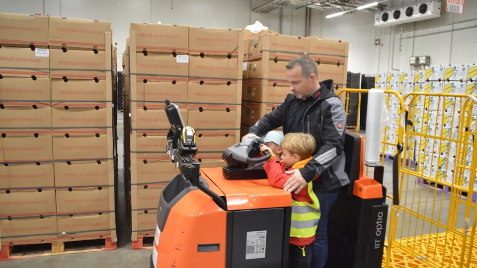 Die Lagerleitung Marco Böhme zeigt zwei Kindern, wie man einen Transportwagen steuert.