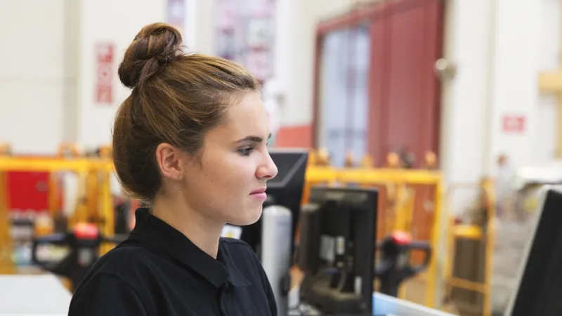 Eine REWE Mitarbeiterin sitzt an der Kasse