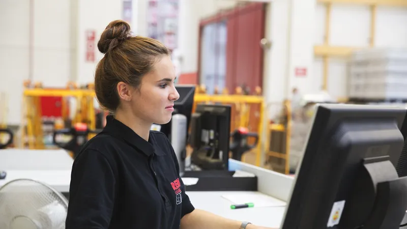 Eine REWE Mitarbeiterin sitzt an der Kasse