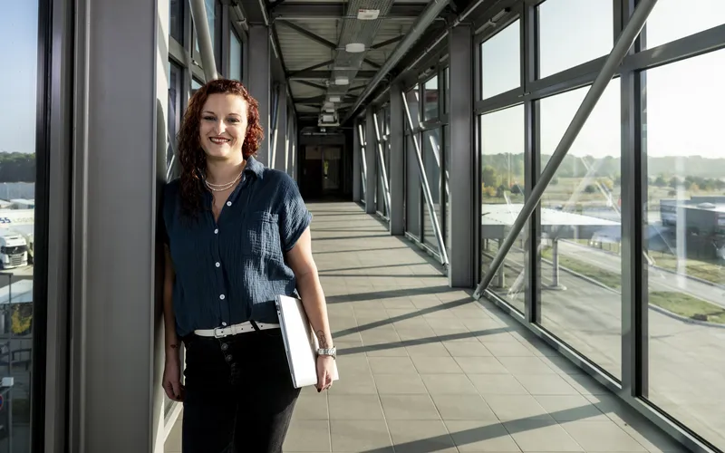 Eine Frau steht in einem Übergang mit einem Schreibblock in der Hand. 