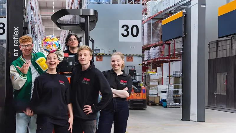 Gruppenbild REWE-Azubis mit anderen in Lagerhalle