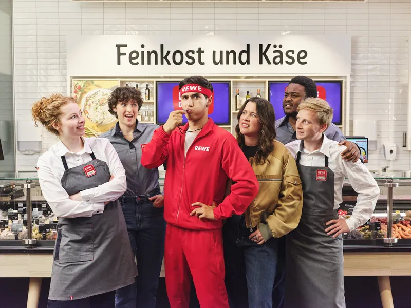 Gruppenbild von REWE-Azubis und andereneiner mit Pfeife